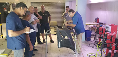 A group of men watching John use the nitrogen plastic welder.