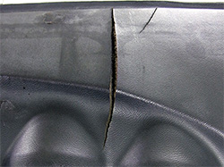 A large split in the vinyl of a Datsun 280Z dashboard.